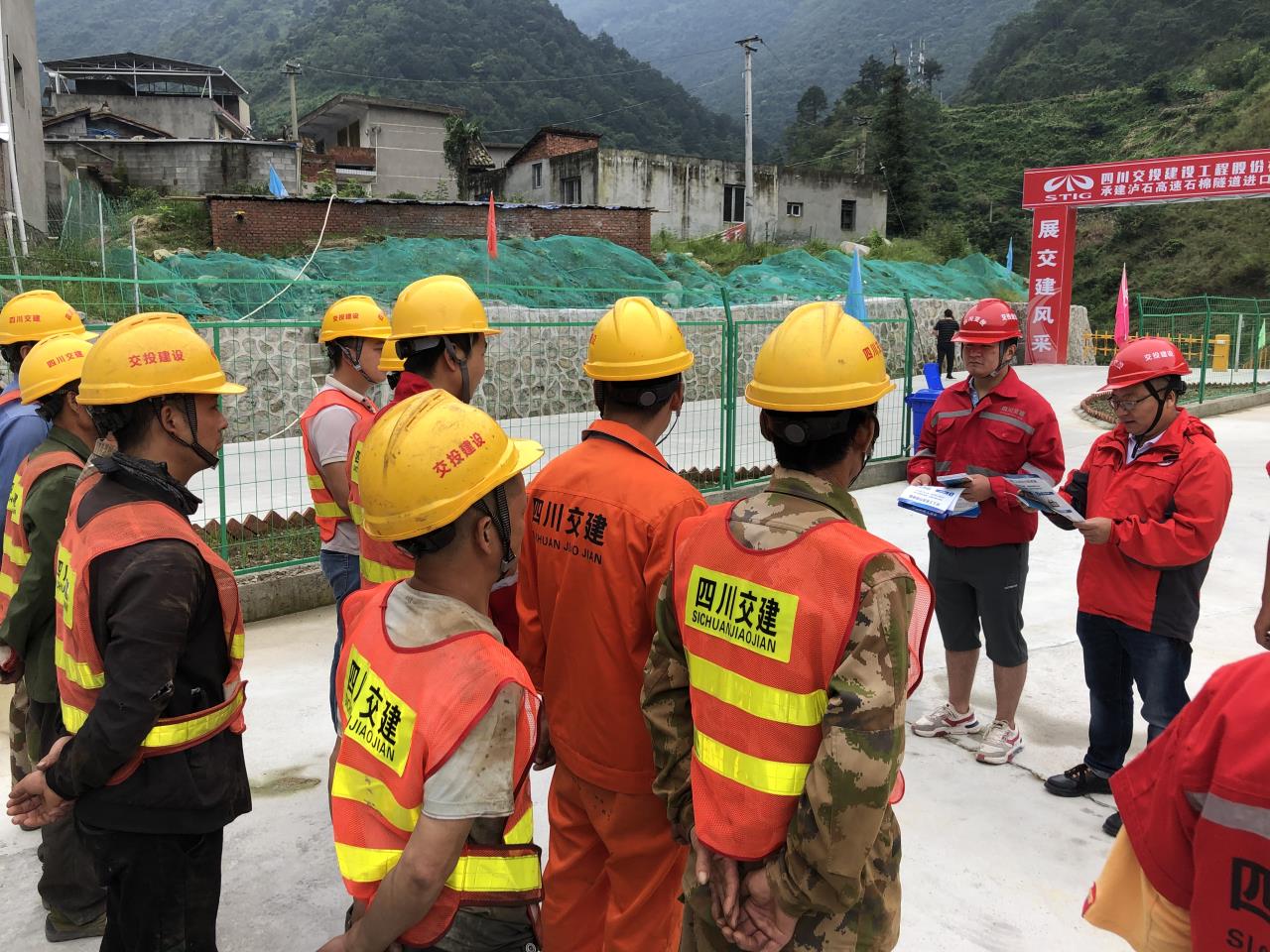 泸石TJ10项目部相关负责人向农民工宣读普法知识.jpg 泸石TJ10项目部相关负责人向农民工宣读普法知识.jpg